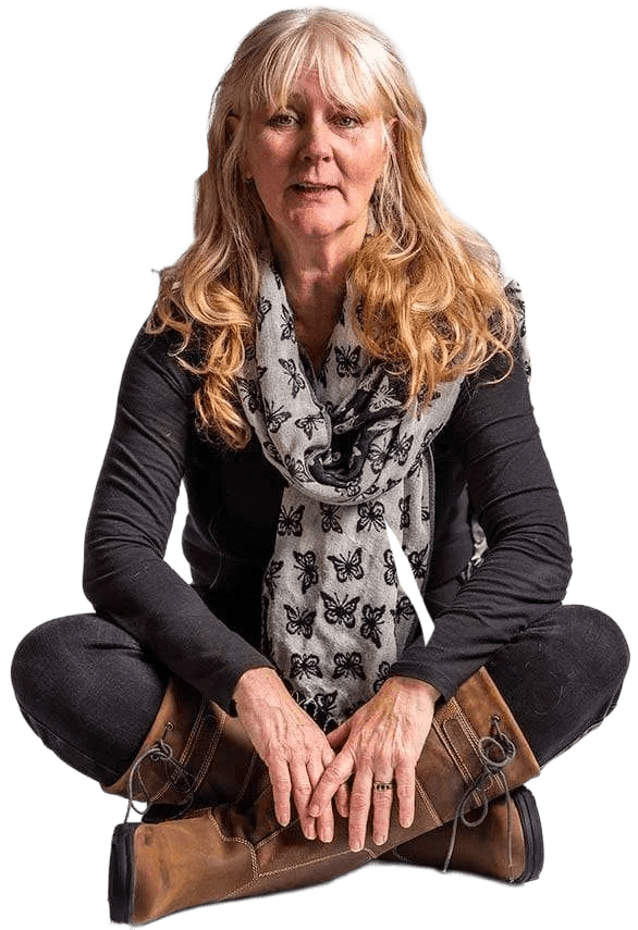 Trudi Dempsey, Equine Clicker Trainer and Behaviourist sits cross legged on the floor.